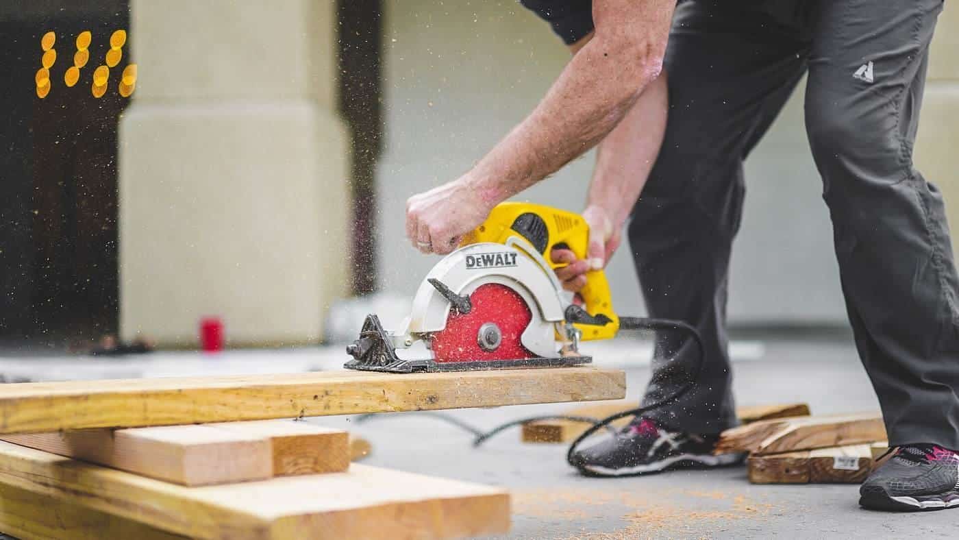 A tradesperson cutting timber with a circular saw